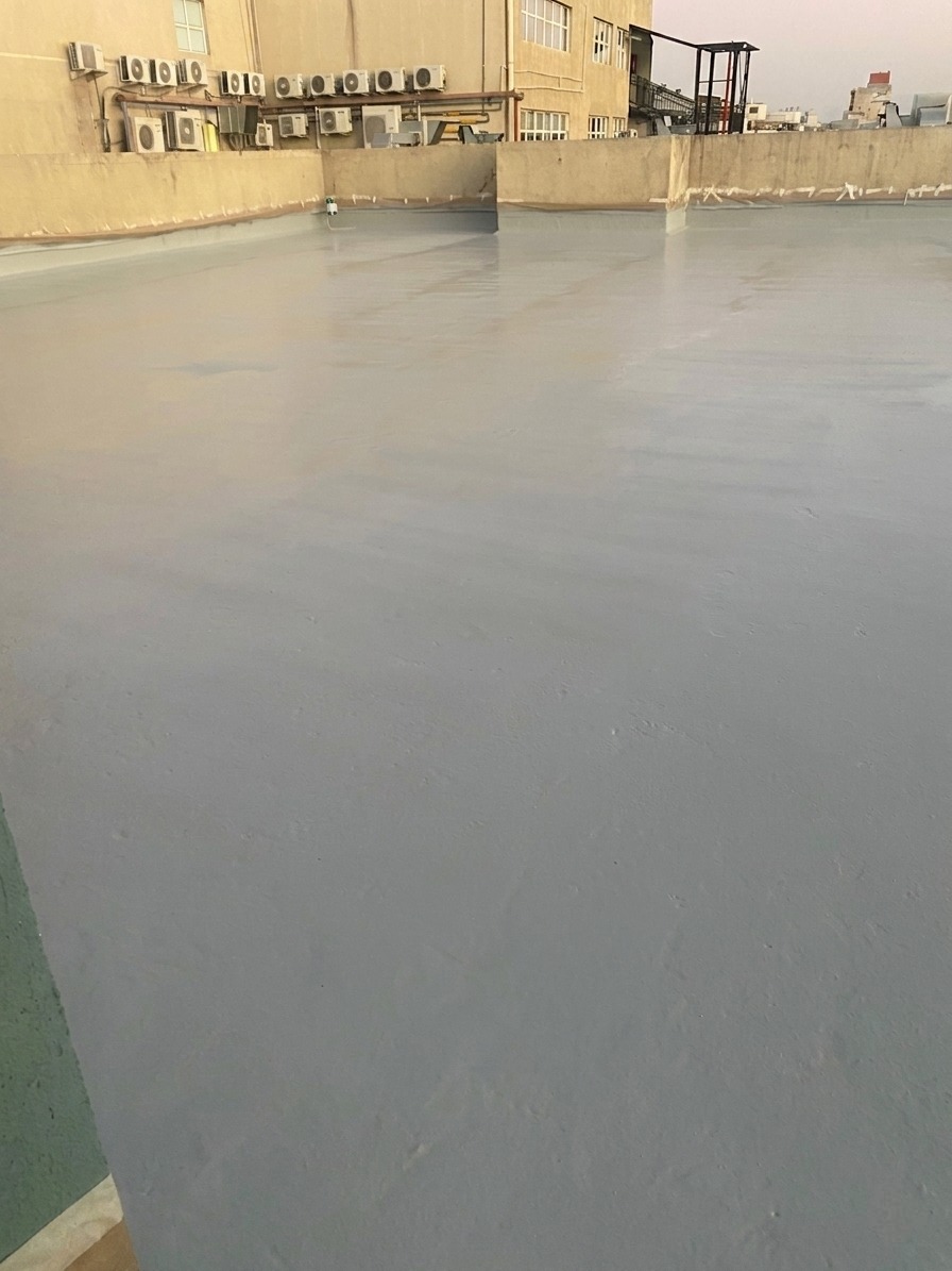 Cubierta del edificio terminada con membrana gris continua entre los equipos de aire acondicionado