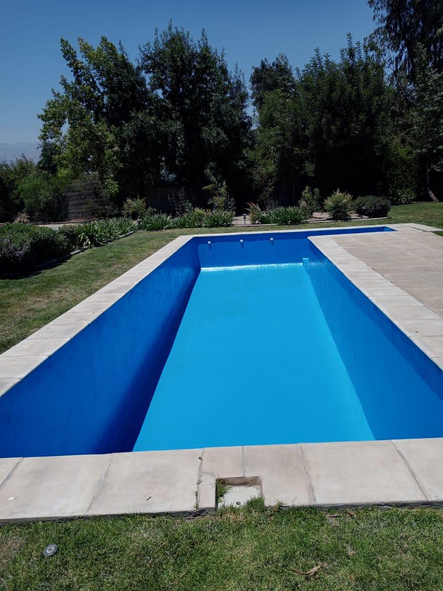 Piscina residencial renovada con revestimiento azul intenso y bordes terminados