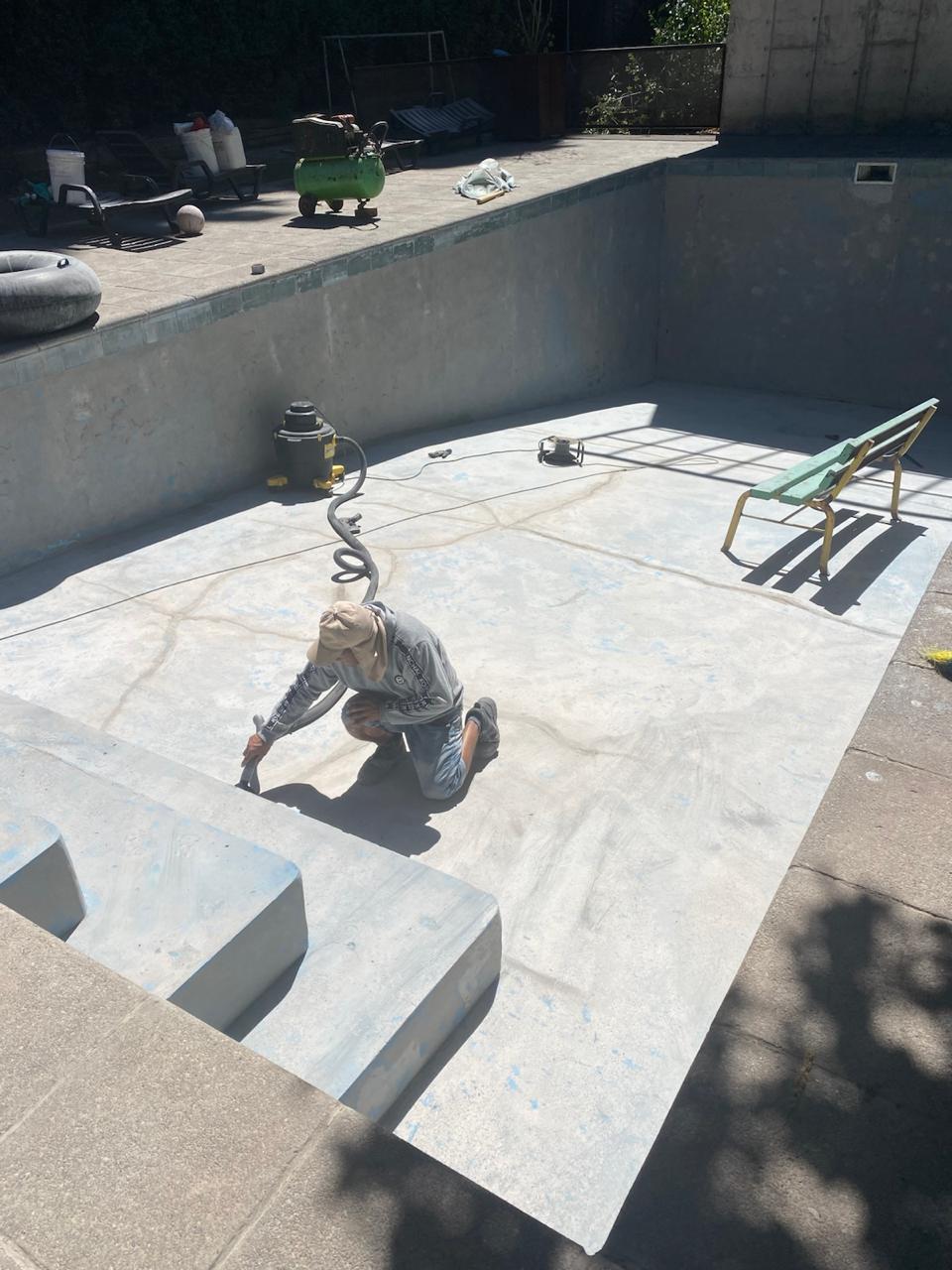 Operario de Aispoltec aplicando recubrimiento impermeable en el interior de una piscina de hormigón